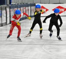 Three young skaters racing